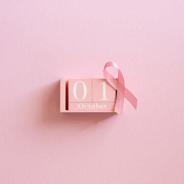 Pink October calendar with breast cancer awareness ribbon on soft pink square background for awareness month