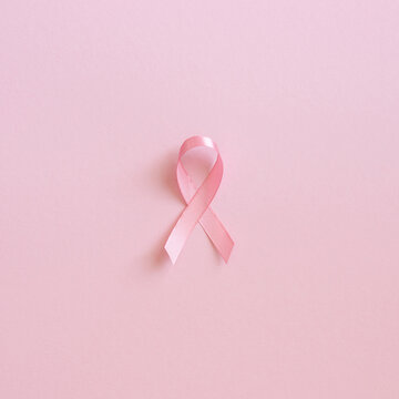 Pink ribbon on soft square pink background for Breast Cancer Awareness month and symbolic cancer support campaign