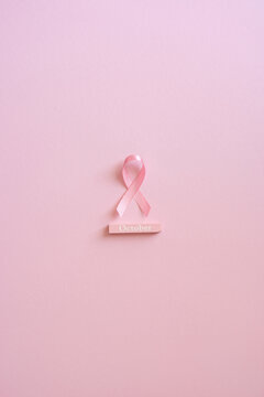 Breast cancer awareness month pink ribbon on soft vertical pink background for October support and hope