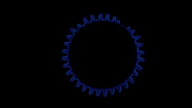 Gas stove burner igniting with blue flame in dark kitchen close up. Macro shot of gas cooker turning on with bright blue fire