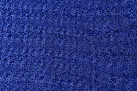 macro of breathable blue mesh fabric texture showing intricate woven patterns and ventilation holes commonly used in modern athletic sportswear and jersey clothing