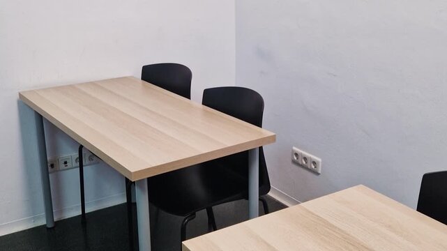 Wooden desk and chairs in the corner of an empty classroom at a language school