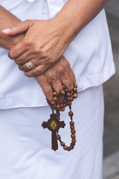 Faithful Hands Holding a Wooden Rosary