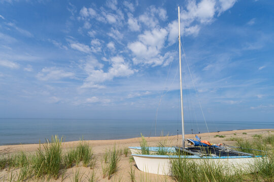 Sailboat resting on sandy Lake Michigan beach in Holland, Michigan