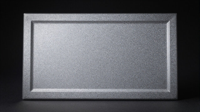 Rectangular metallic plaque with a beveled frame on a dark background