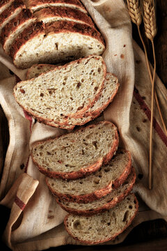Artisan Bread Still Life. A fresh baked and sliced loaf of multi grain bread on a kitchen towel.