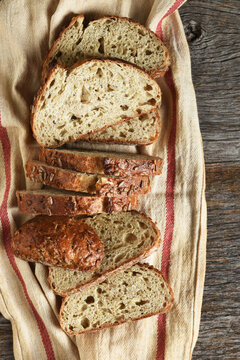 Artisan Bread Still Life. A fresh baked and sliced loaf of multi grain bread on a kitchen towel.