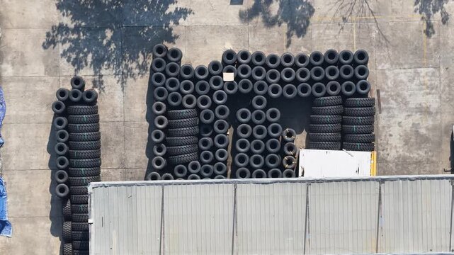 Stacks of black rubber tires organized for distribution at an industrial storage facility site