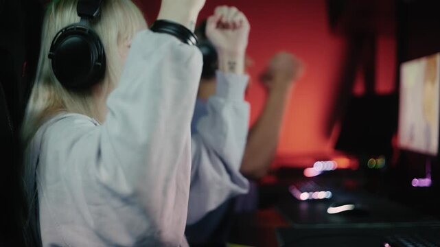 Professional esports players celebrating a win and high-fiving during a video game championship
