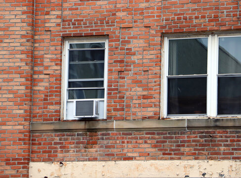 Red brick building wall with double windows and stone sills