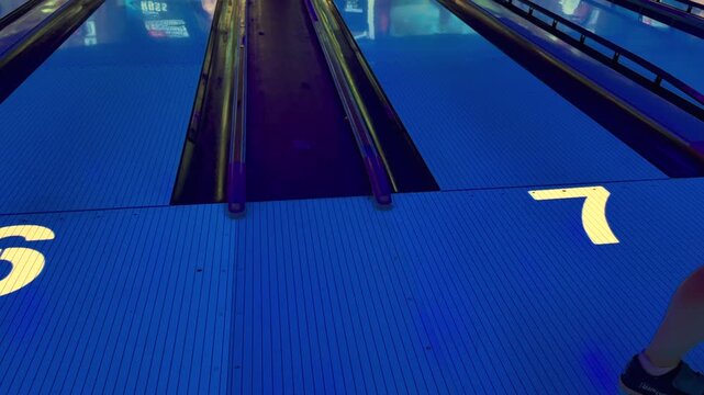 Lanes 6 and 7 at glowing bowling alley with blue neon lighting, representing viral 6-7 internet meme, sports recreation, night bowling fun - six seven