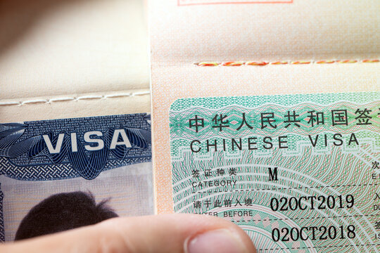 Both a China visa and a United States visa inside open passport pages. Ideal image for international relations, global travel, diplomatic affairs, trade, travel permits, and immigration topics.
