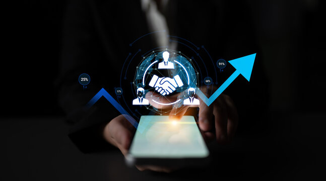 Business collaboration concept with hands shaking on smartphone screen and data visualization on dark background for digital marketing and partnership growth. Sentient.