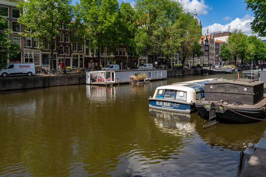 Typical canal houses boats near traditional brick buildings Amsterdam
