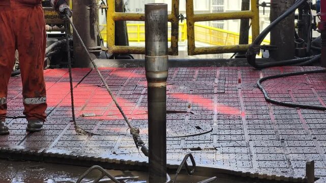 Rig crew perform pulling of of hole drill string with oil based mud on the rig floor. Trip out of hole.