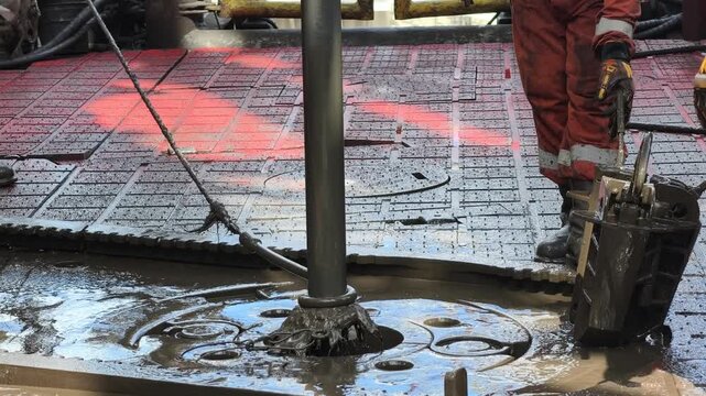 Rig crew perform pulling of of hole drill string with oil based mud on the rig floor. Trip out of hole.