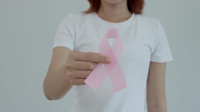 Woman hold pink ribbon breast cancer awareness. Female health check consciousness. international Women Day and World Cancer Day. sign cancer, Symbolic, health care, support patients, timely diagnosis