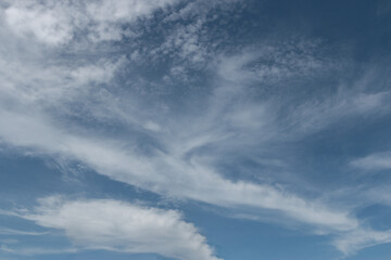 Obraz premium blue sky with a dramatic scattering of white clouds. blue sky background.