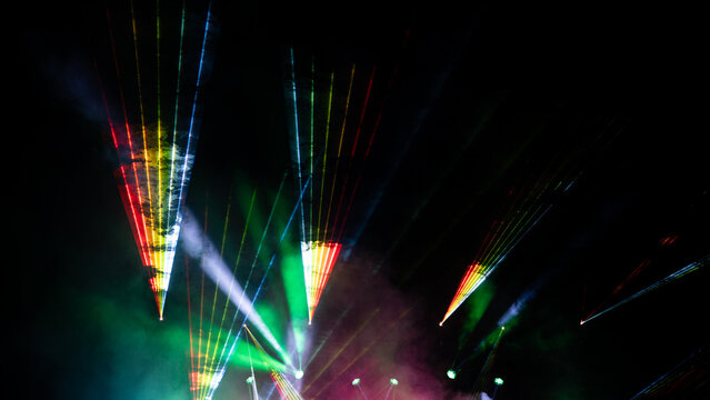 View of a vibrant laser light show illuminating the night sky at the Oregon Country Fair in Veneta, Oregon, United States.