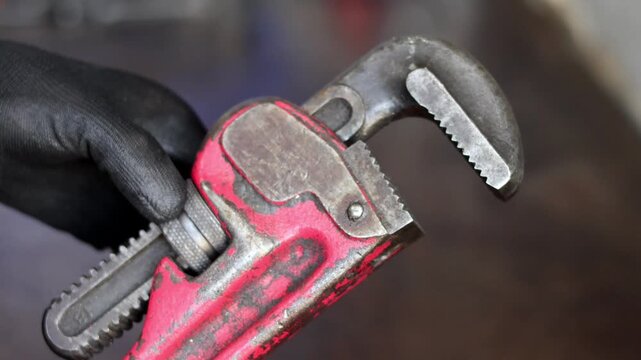Mechanic Holding Red Pipe Wrench Tool.