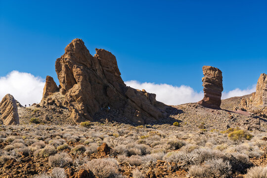 View of the iconic rock formations of Roques de Garcia in Teide National Park with rugged volcanic terrain and clear blue sky in Santa Cruz de Tenerife, Canary Islands, Spain.