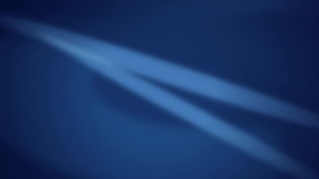Blue light beams cast a soft glow across a dark surface