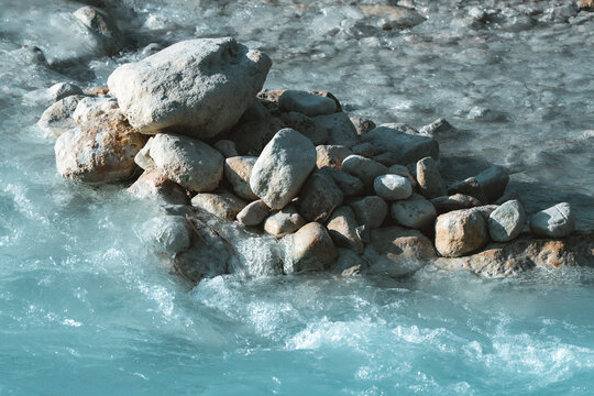 Aerial view of the turquoise thermal waters flowing over natural rock formations at the Cascate del Mulino in Saturnia, Tuscany, Italy.