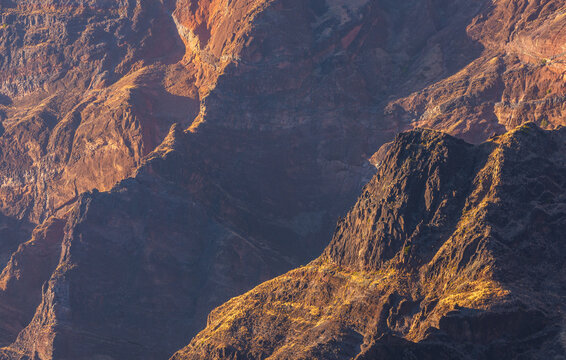 View of the rugged volcanic mountain landscape of Santo Antao with steep rocky cliffs illuminated by golden hour light in Alto Mira, Porto Novo, Cabo Verde.