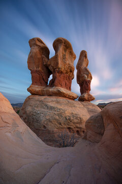View of the unique sandstone hoodoos in the desert landscape under a dramatic long exposure sky in Escalante, Utah, United States.