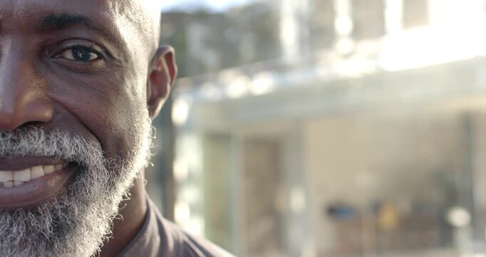 African American man smiling, turning neutral face into wide smile by glass facade, copy space