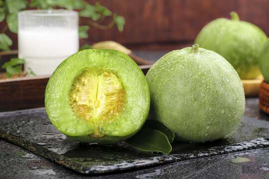 Fresh Green Melon Cut in Half with Seeds Display on Slate Board in Rustic Kitchen Setting