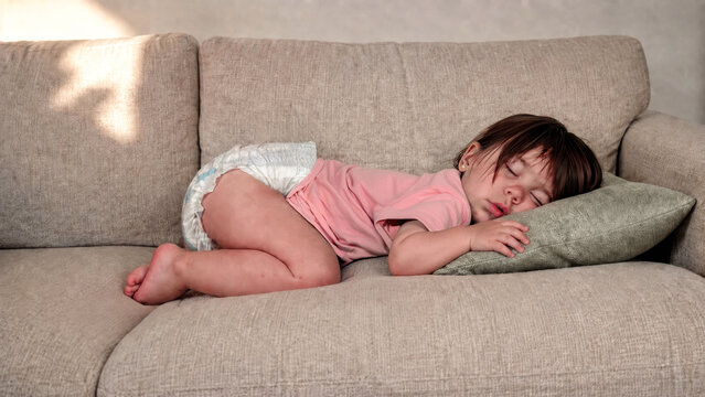 One Year Old Toddler Curled Up for an Afternoon Nap on the Sofa