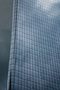 View of the modern glass facade of a skyscraper reflecting the sky in Calgary, Alberta, Canada.