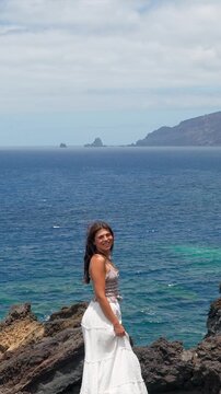 Young woman enjoying the ocean view on a windy day