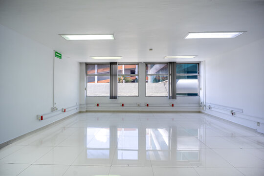 Symmetrical one-point perspective of an empty modern corporate room with window reflections