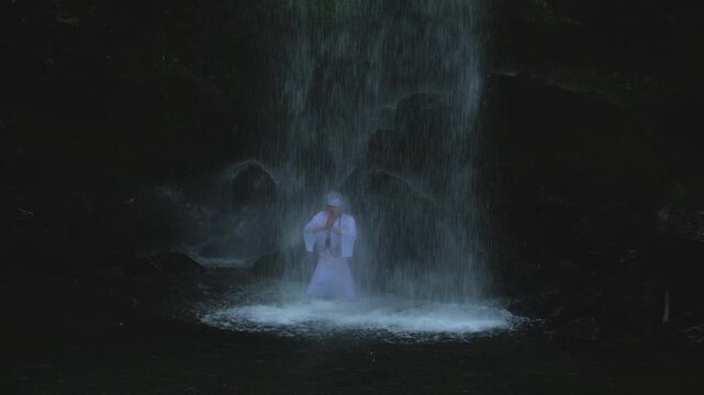 August 9 2026, Kanagawa Prefecture, Japan; man performing meditation under Yuhi no Taki waterfall in Kanagawa Prefecture.