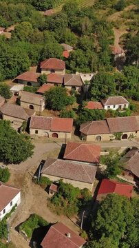 Aerial around view of old rustic vintage houses with wine cellars in Rogljevacke pivnice in Negotin region of Serbia. Vertical video 4k