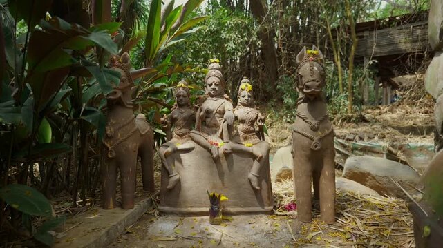 Handcrafted terracotta Ayyanar deity sculpture surrounded by green plants
