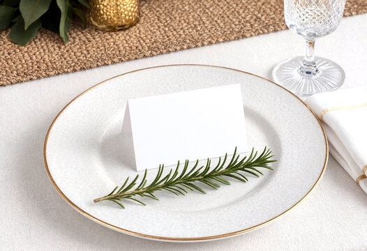Elegant table setting with a white place card and rosemary sprig on plate for formal dinner event