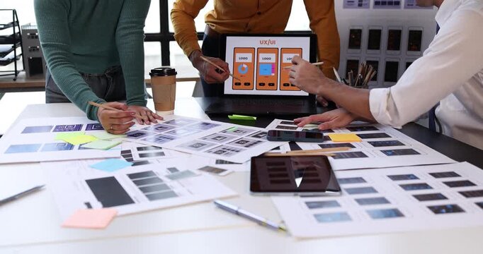 Uxui designers collaborating on a new mobile application interface, discussing wireframes and app prototypes