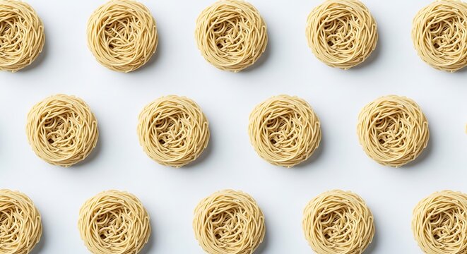 Nests of dry pasta, a staple food, arranged in a repeating pattern on a white background.