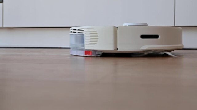 Smart vacuum cleaner cleans the floor in the apartment. A smart home, housekeeping concept