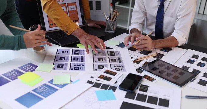 Uxui designers collaborating on a new mobile application interface, discussing wireframes and app prototypes