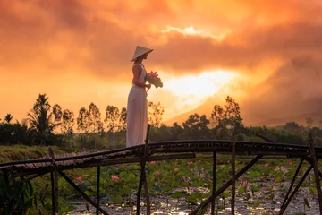 Fotobehang Lotusbloem Serene Sunset Moment with Lotus at Traditional Vietnamese Pond  © Buyanskyy Production
