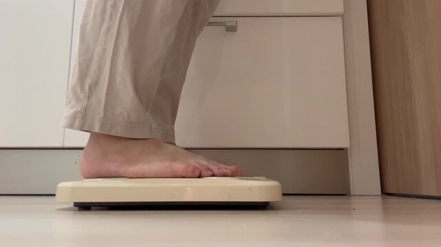 体重計に乗る女性の足元