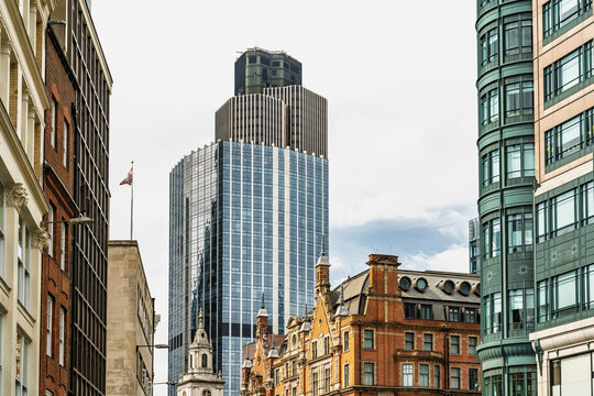 View of the modern glass skyscraper rising above historic brick buildings near Liverpool Street in London, England, United Kingdom.