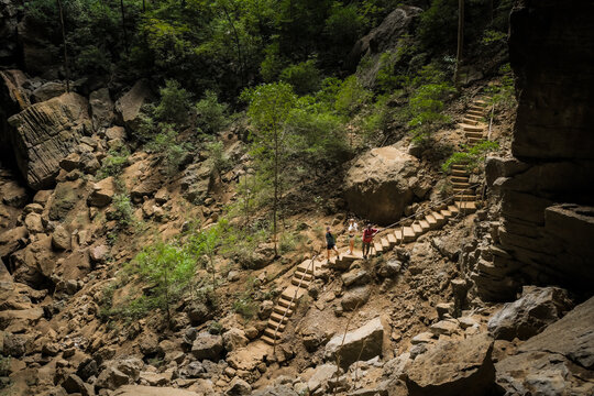 View of hikers walking up a stone staircase through the rocky terrain of the Reserve speciale d Ankarana in Diana, Madagascar.