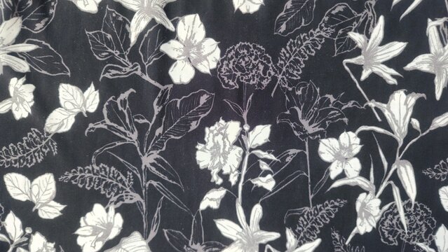 Monochromatic floral pattern with lilies and leaves on a dark background
