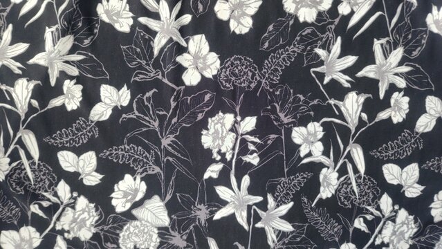 Monochromatic floral pattern with white and grey flowers and leaves on a dark background