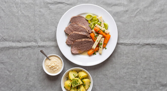 Classic Austrian Tafelspitz boiled beef slices with root vegetables boiled potatoes and horseradish sauce